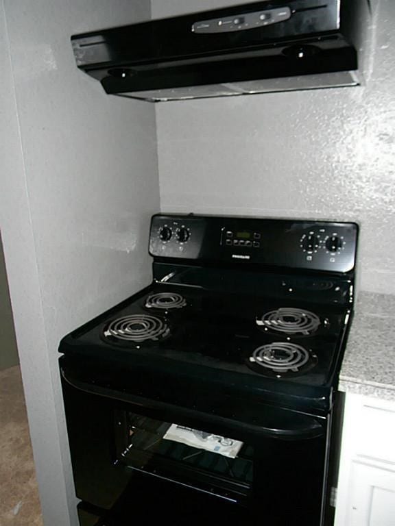 interior details with electric range, range hood, and white cabinets