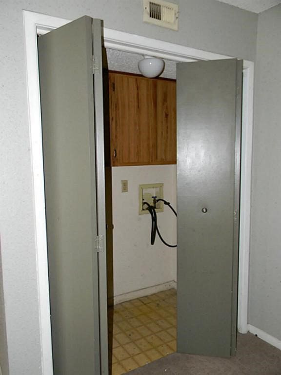 clothes washing area with tile floors and hookup for a washing machine