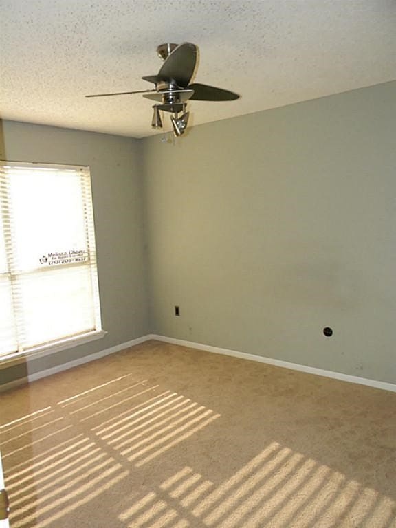 carpeted empty room featuring a textured ceiling and ceiling fan