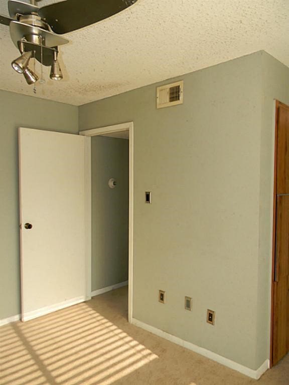 interior space with a textured ceiling and carpet floors