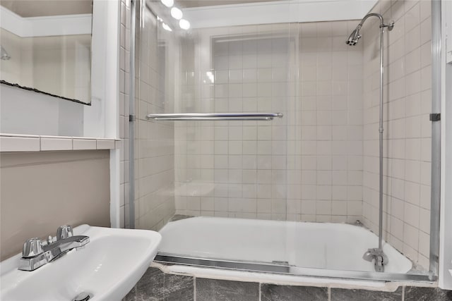 bathroom featuring sink and combined bath / shower with glass door