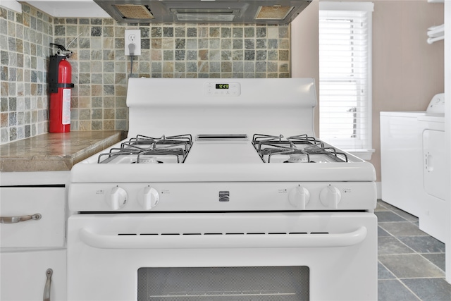 interior details with washer / clothes dryer, white range with gas cooktop, and dark tile floors