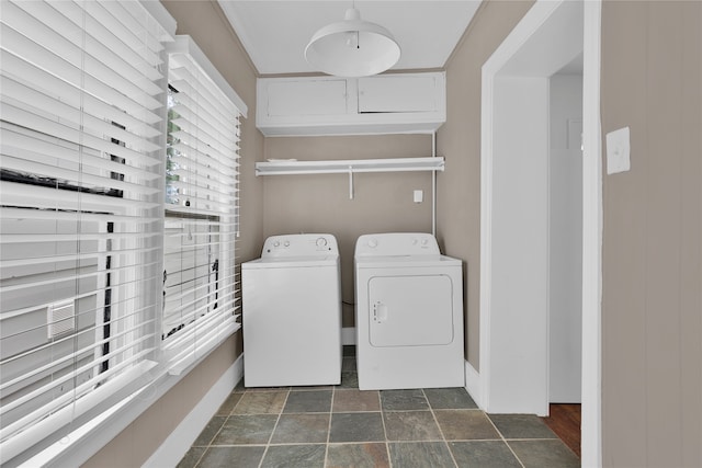 clothes washing area with washer and dryer and dark tile flooring