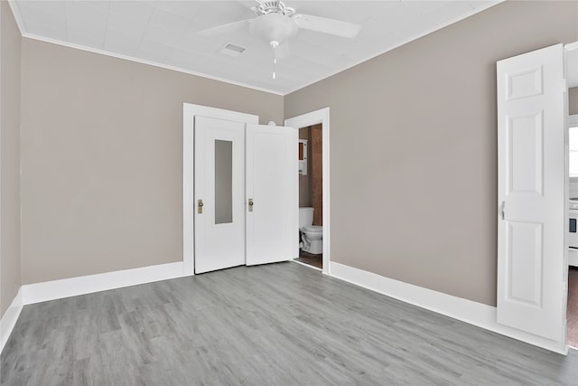 unfurnished bedroom featuring crown molding, hardwood / wood-style flooring, ceiling fan, and ensuite bath