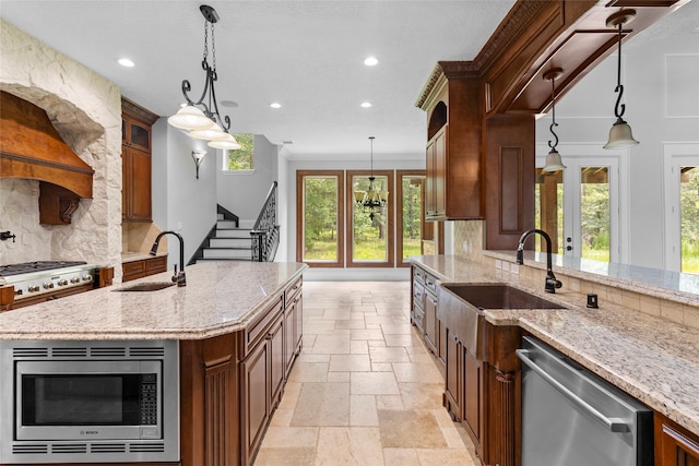 kitchen with hanging light fixtures, a wealth of natural light, backsplash, and appliances with stainless steel finishes