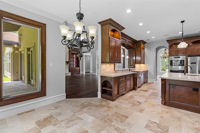 kitchen featuring crown molding, stainless steel appliances, light stone counters, backsplash, and pendant lighting