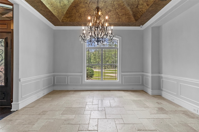 tiled spare room featuring ornamental molding, a tray ceiling, and a chandelier