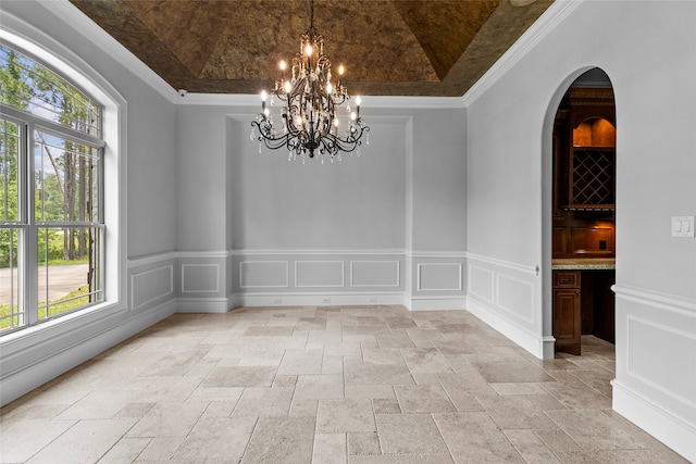 unfurnished dining area with light tile floors, ornamental molding, and a raised ceiling