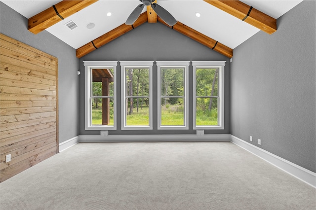 spare room with a wealth of natural light, lofted ceiling with beams, carpet, and ceiling fan