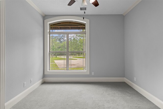 carpeted empty room with ornamental molding, ceiling fan, and a textured ceiling