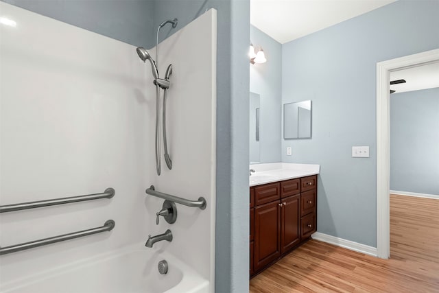 bathroom featuring wood-type flooring, vanity, and shower / washtub combination