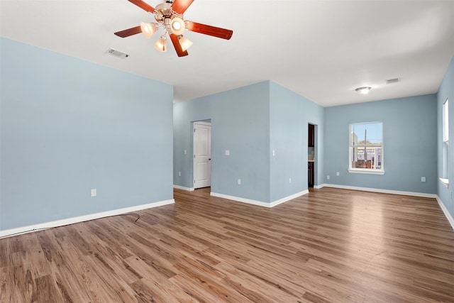 empty room with hardwood / wood-style flooring and ceiling fan