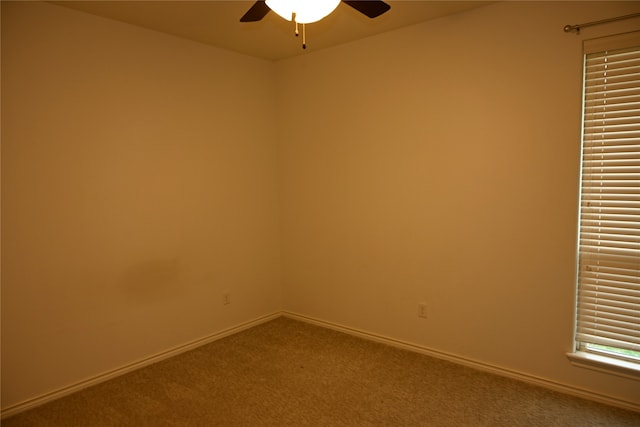 carpeted spare room featuring ceiling fan