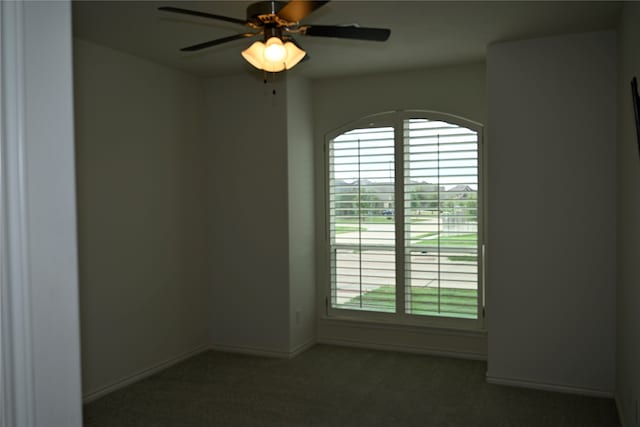 unfurnished room with ceiling fan and dark colored carpet