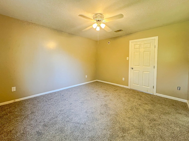 spare room featuring carpet flooring, ceiling fan, and a textured ceiling