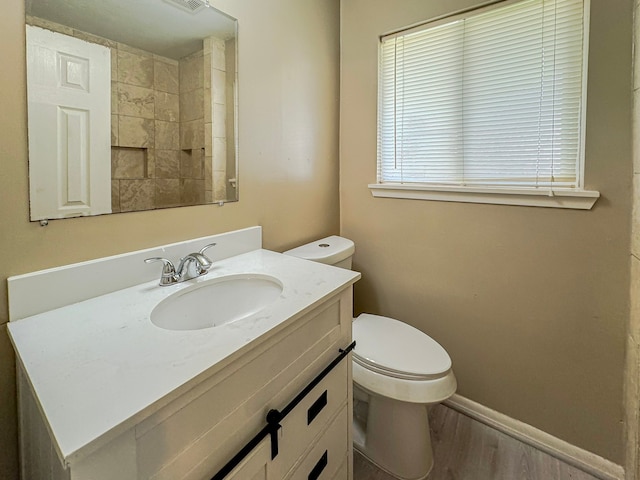 bathroom with wood-type flooring, toilet, and vanity