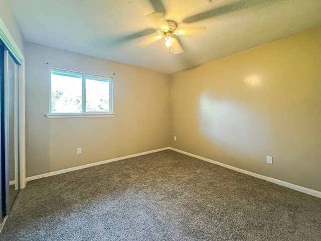 carpeted spare room featuring ceiling fan and a textured ceiling