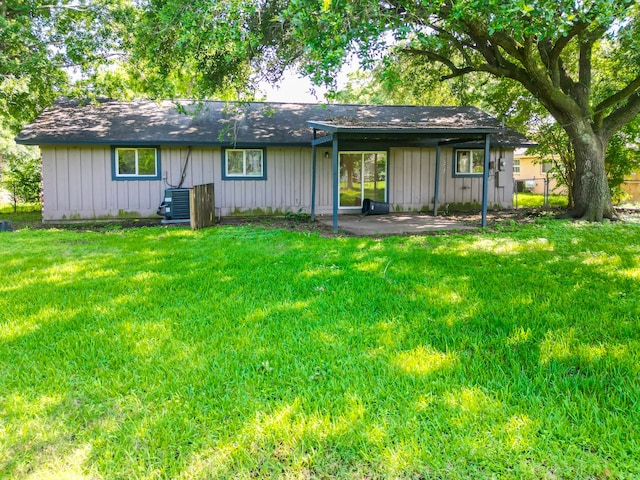 back of house with central AC and a yard