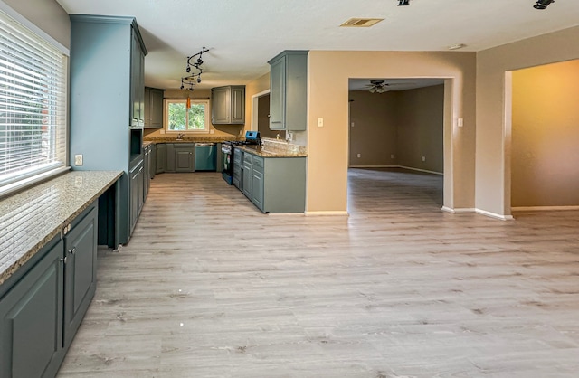 kitchen featuring gas stove, stainless steel dishwasher, light hardwood / wood-style flooring, light stone counters, and ceiling fan