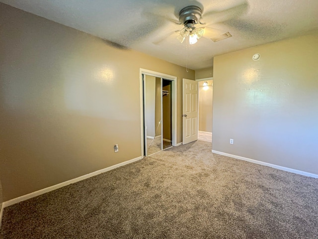 unfurnished bedroom featuring a textured ceiling, carpet floors, and ceiling fan