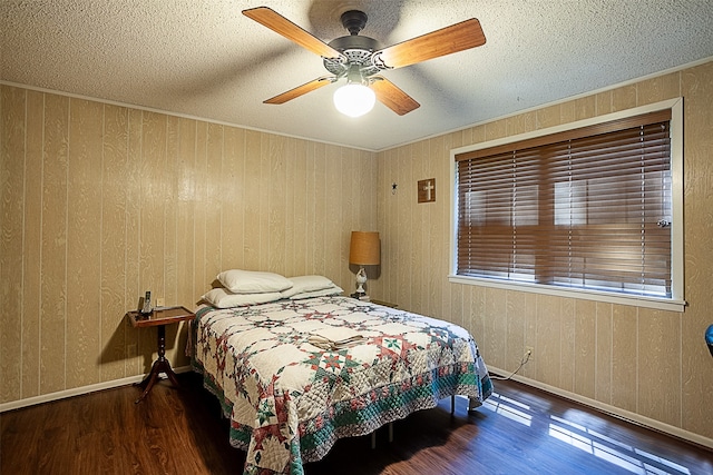 bedroom featuring dark hardwood / wood-style flooring, ceiling fan, and a textured ceiling