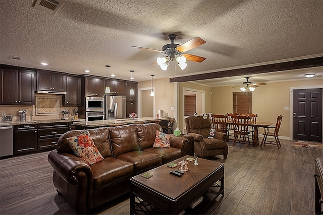 living room with a textured ceiling, ceiling fan, and dark hardwood / wood-style floors