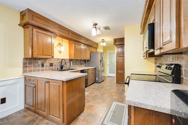 kitchen featuring appliances with stainless steel finishes, tile floors, kitchen peninsula, backsplash, and sink