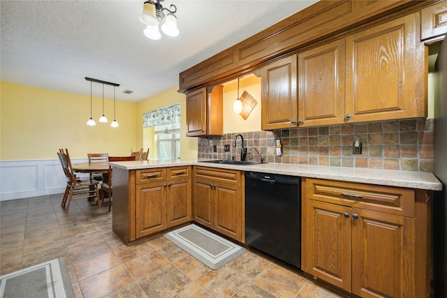 kitchen with decorative light fixtures, kitchen peninsula, dishwasher, backsplash, and sink