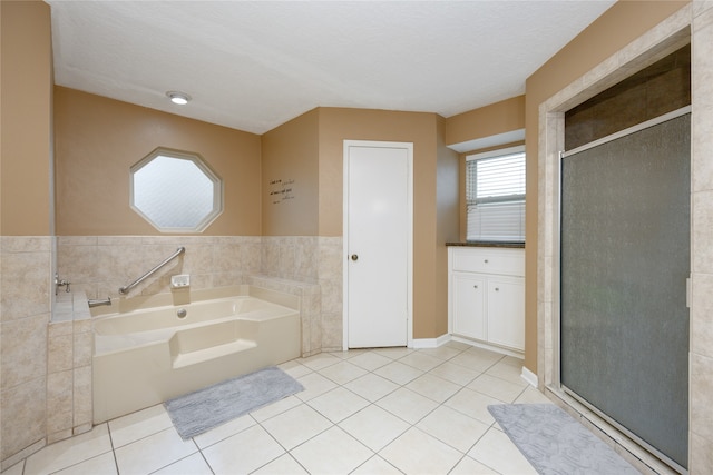 bathroom with tile floors, shower with separate bathtub, a textured ceiling, and tile walls