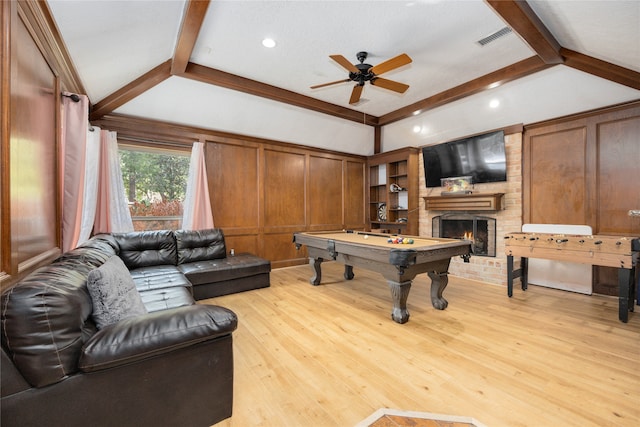 living room with brick wall, a brick fireplace, light hardwood / wood-style flooring, billiards, and ceiling fan