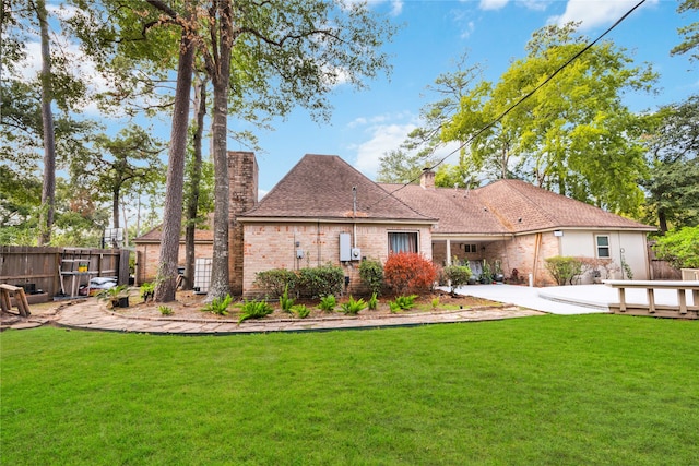 back of house with a lawn and a patio area