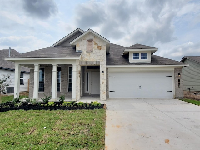 view of front of property featuring central air condition unit, a front yard, and a garage