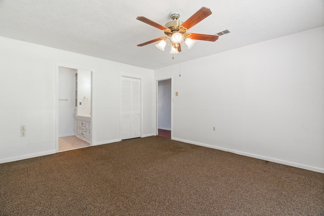 unfurnished bedroom with ceiling fan, ensuite bathroom, and light carpet