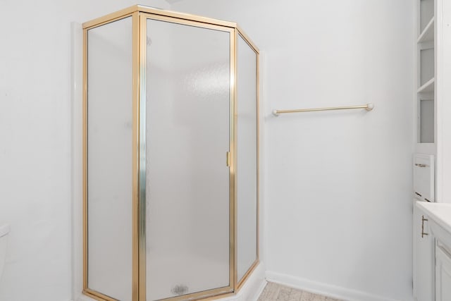 bathroom with an enclosed shower, vanity, and hardwood / wood-style floors