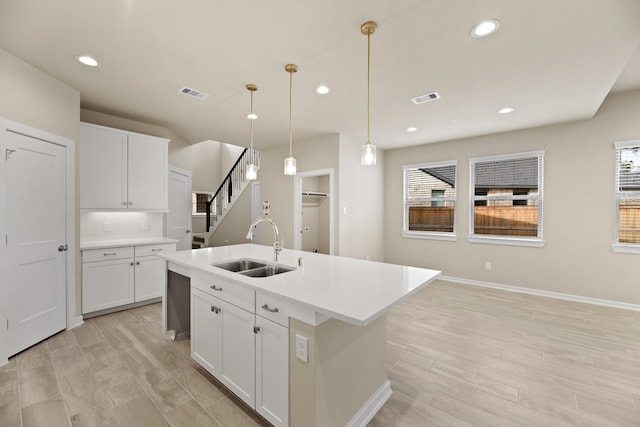 7823 Open Point Dr, Cypress, TX 77433 - kitchen featuring an island with sink, sink, plenty of natural light, and white cabinetry