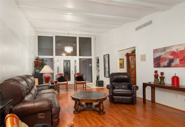 living room featuring beam ceiling, hardwood / wood-style flooring, and french doors