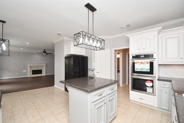 kitchen with double oven, hanging light fixtures, white cabinets, and crown molding