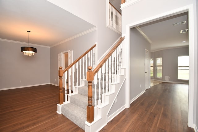 staircase featuring an inviting chandelier, dark hardwood / wood-style flooring, and crown molding