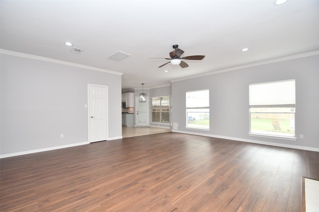 unfurnished living room with ceiling fan, crown molding, and dark tile floors