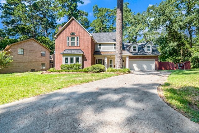 view of property with a garage and a front lawn