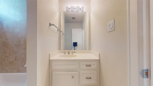 bathroom featuring tiled shower / bath combo and vanity