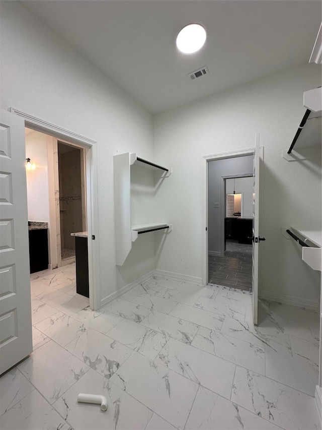 walk in closet with light tile patterned floors