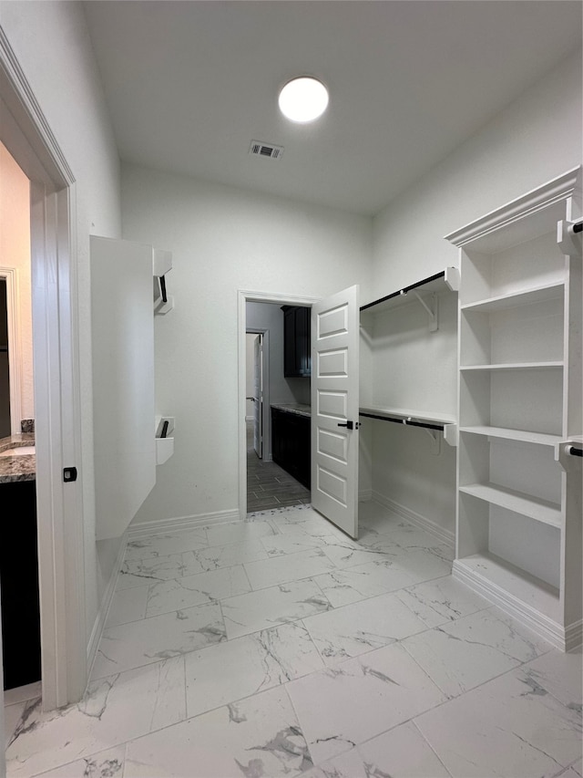 walk in closet featuring light tile patterned flooring