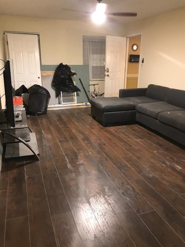 living room featuring ceiling fan and dark hardwood / wood-style floors