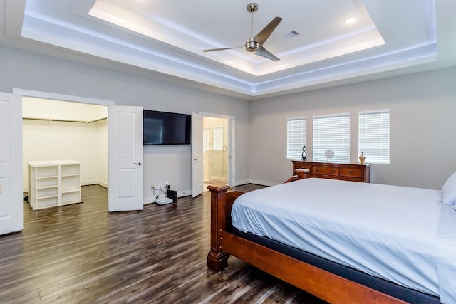 bedroom featuring a tray ceiling, ceiling fan, and dark hardwood / wood-style flooring