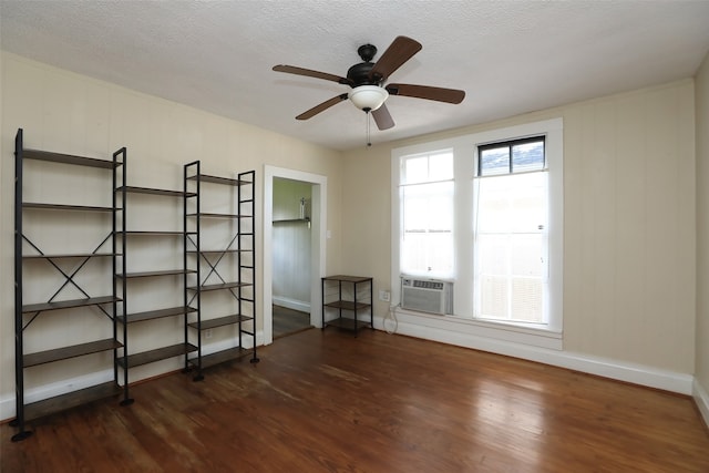 interior space with dark hardwood / wood-style floors, a textured ceiling, cooling unit, and ceiling fan