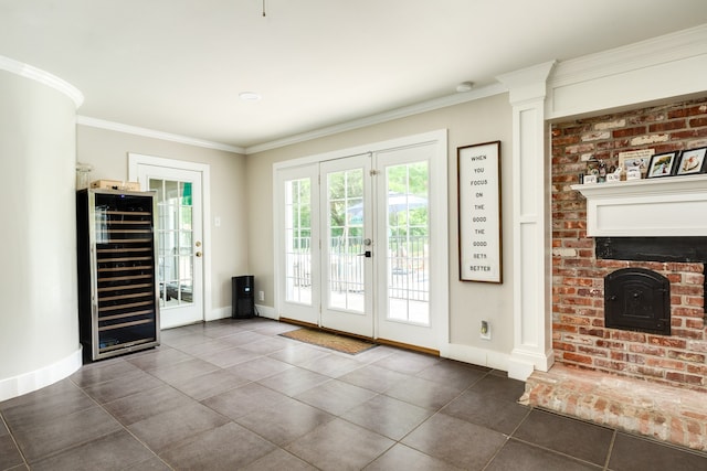 entryway with tile flooring, french doors, a fireplace, and ornamental molding