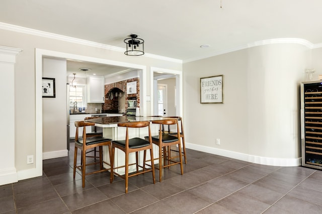 dining room with ornamental molding and dark tile flooring