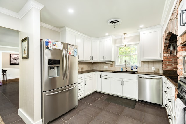 kitchen featuring hanging light fixtures, appliances with stainless steel finishes, sink, tasteful backsplash, and dark tile flooring