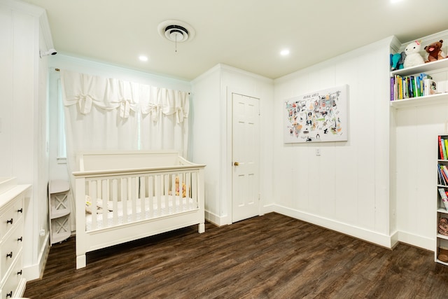 unfurnished bedroom with dark wood-type flooring and a crib